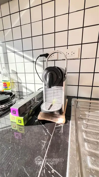 Modern kitchen with sleek coffee machine and tiled backsplash