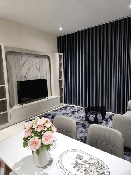 Elegant living room with modern decor, plush rug, and stylish furniture, perfect for relaxation and entertainment.