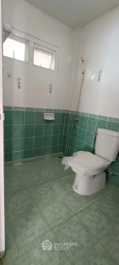 Spacious bathroom with green tile design and modern fixtures