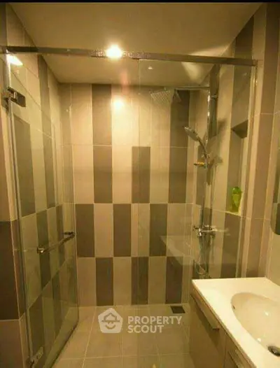 Modern bathroom with glass shower enclosure and stylish tile design.