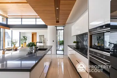 Sleek modern kitchen with high-end built-in appliances, glossy countertops, and warm wooden accents complemented by abundant natural light.