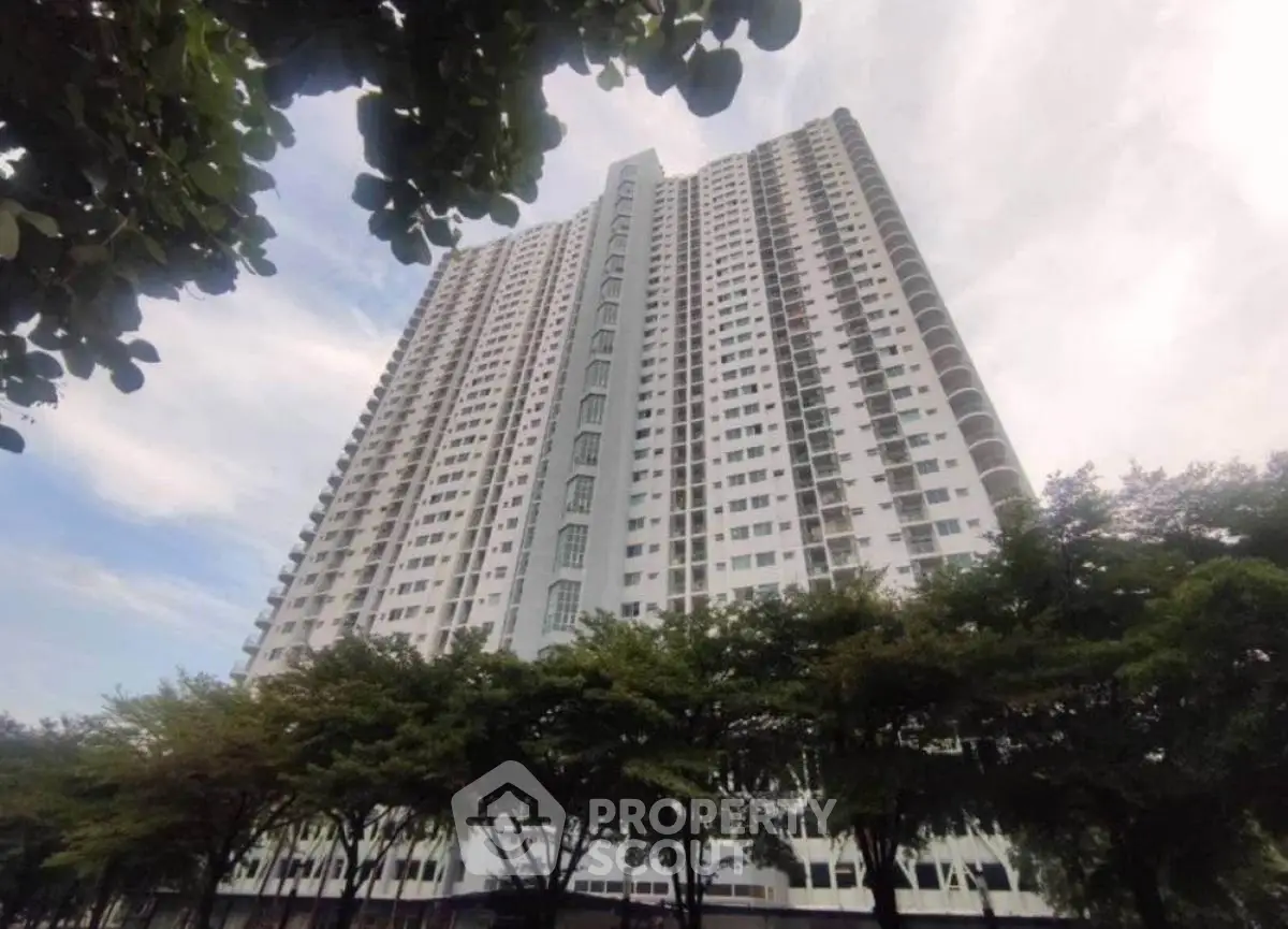 Stunning high-rise apartment building with lush greenery and expansive sky view.