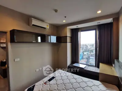 Modern bedroom with city view, featuring built-in storage and air conditioning.