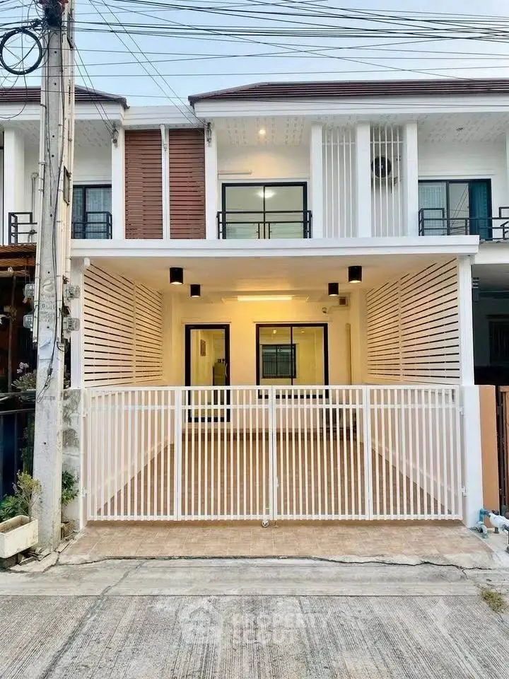 Modern townhouse exterior with gated entrance and sleek design.