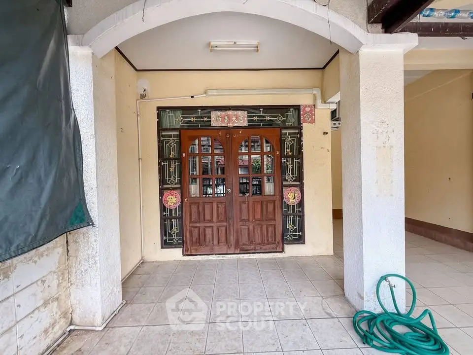 Charming entrance with traditional wooden door and decorative glass panels, perfect for a cozy home.