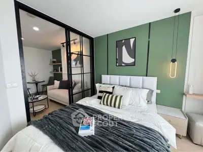 Modern bedroom with stylish decor and cozy seating area, featuring green accent wall and contemporary lighting.