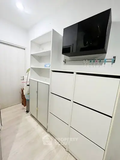 Modern storage room with sleek white cabinets and ample shelving space.