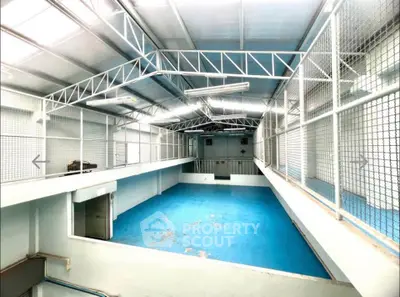 Spacious industrial warehouse with high ceilings and ample natural light.