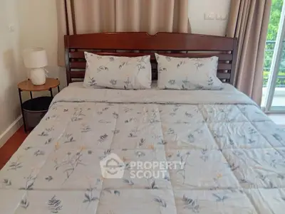 Cozy bedroom with elegant wooden bed and floral bedding, featuring a serene balcony view.
