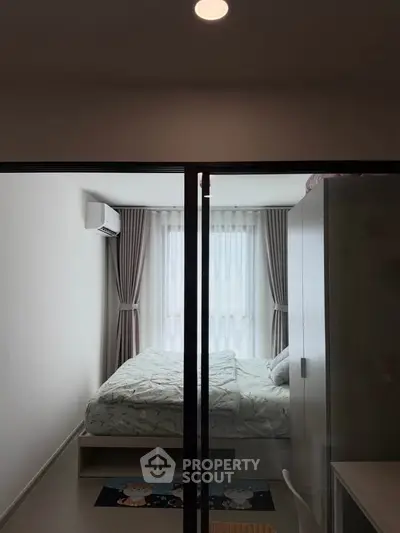 Cozy bedroom with modern decor and large window for natural light