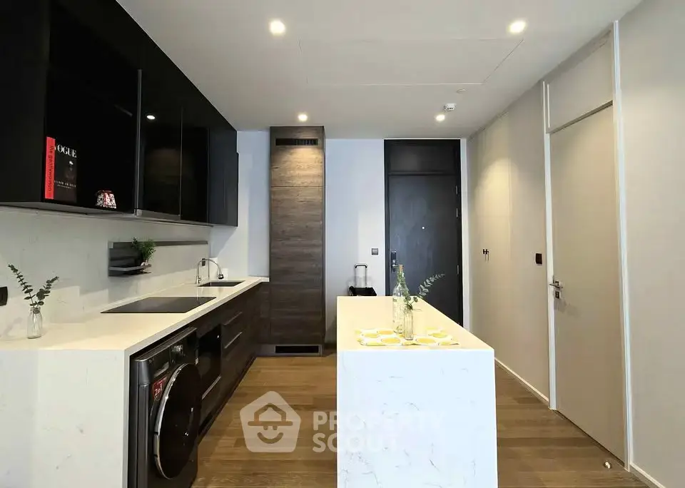 Modern kitchen with sleek design, featuring an island and integrated appliances in a contemporary apartment.