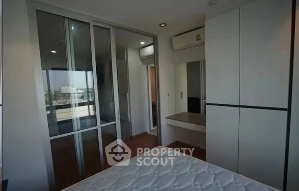 Modern bedroom with sliding glass doors and built-in wardrobe