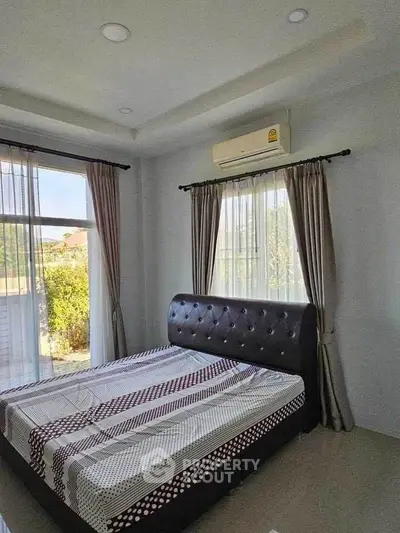 Bright and cozy bedroom with modern decor and large windows for natural light.