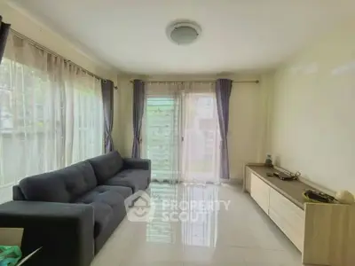 Spacious living room with modern sofa and large windows offering natural light