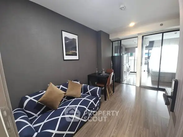 Modern living room with stylish decor and open layout leading to a bright bedroom.