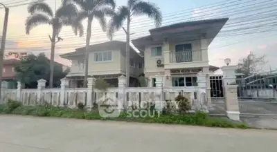 Charming suburban two-story house with lush palm trees and gated entrance.