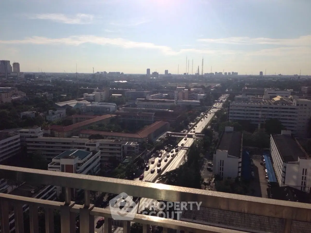 Stunning cityscape view from a high-rise balcony showcasing urban skyline and bustling streets.