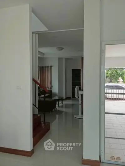 Spacious modern living area with sleek staircase and large windows