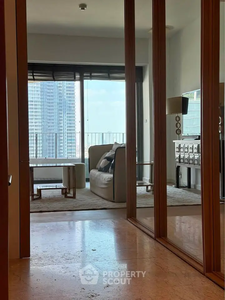Stylish living room with floor-to-ceiling windows and city view, featuring modern furniture and elegant decor.