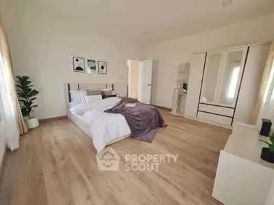Spacious modern bedroom with elegant decor and wooden flooring
