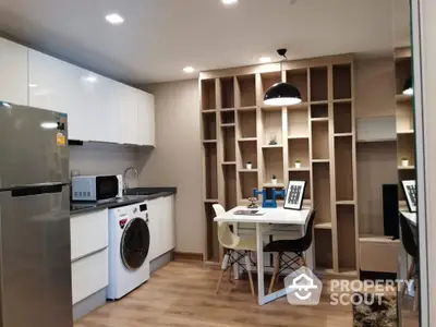 Modern kitchen with dining area, sleek appliances, and stylish shelving