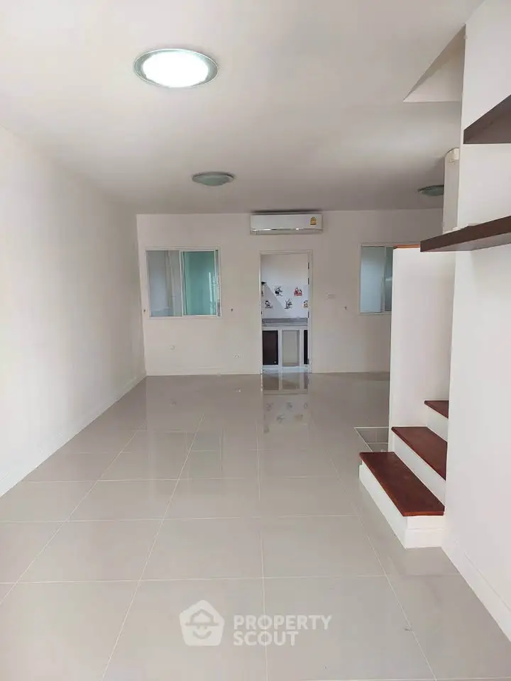 Spacious modern living room with sleek tile flooring and built-in air conditioning.