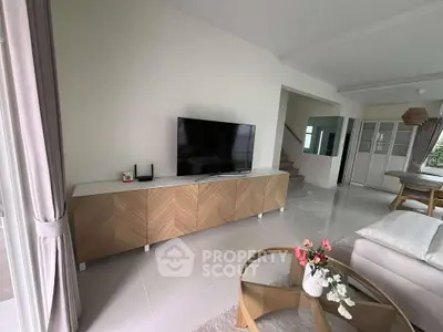 Modern living room with sleek TV console and stylish decor, featuring a cozy seating area and elegant furnishings.