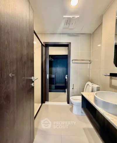 Modern bathroom with sleek design, featuring a glass shower, elegant vanity, and spacious layout.