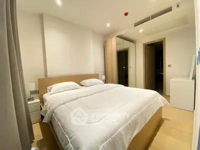 Modern bedroom with cozy bed and wooden wardrobe in a stylish apartment