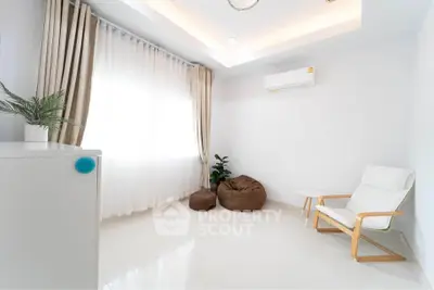Bright minimalist living room with modern chair and bean bags, perfect for relaxation.