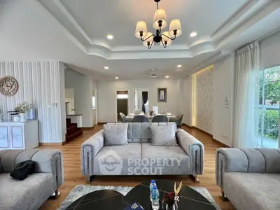 Luxurious living room with elegant decor and modern furniture, featuring a stylish chandelier and spacious layout.