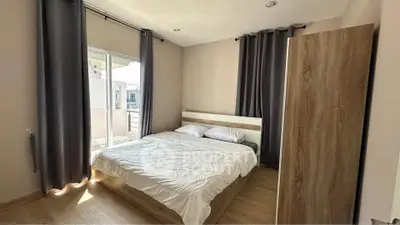 Cozy bedroom with natural light and modern furnishings, ideal for relaxation.