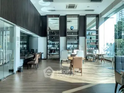 Modern library with floor-to-ceiling windows and stylish seating in a luxury building.
