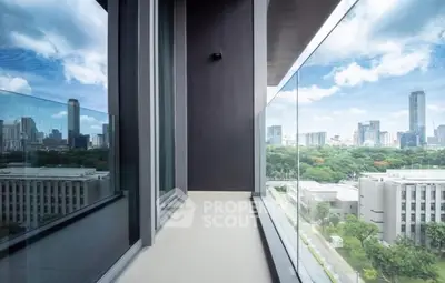 Stunning city view from modern high-rise balcony with glass railing.