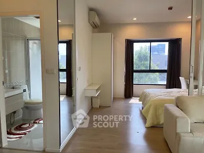 Modern studio apartment with open layout, featuring a cozy bedroom and stylish bathroom.