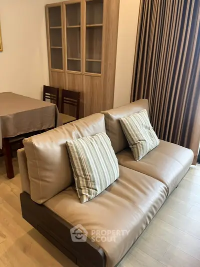 Modern living room with stylish sofa and dining area, featuring elegant wood furniture and cozy ambiance.