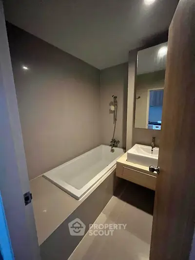Modern bathroom with sleek bathtub and stylish sink in a contemporary apartment.
