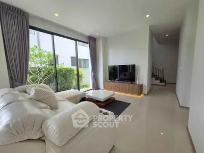 Spacious modern living room with large windows and stylish furniture in a bright, airy home.
