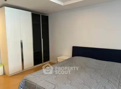 Spacious bedroom with modern wardrobe and cozy bed in a stylish apartment.