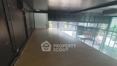 Spacious modern loft with large windows and wooden flooring, ideal for creative workspace or studio.