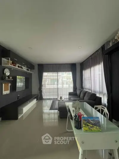 Modern living room with sleek furniture and large windows for natural light.
