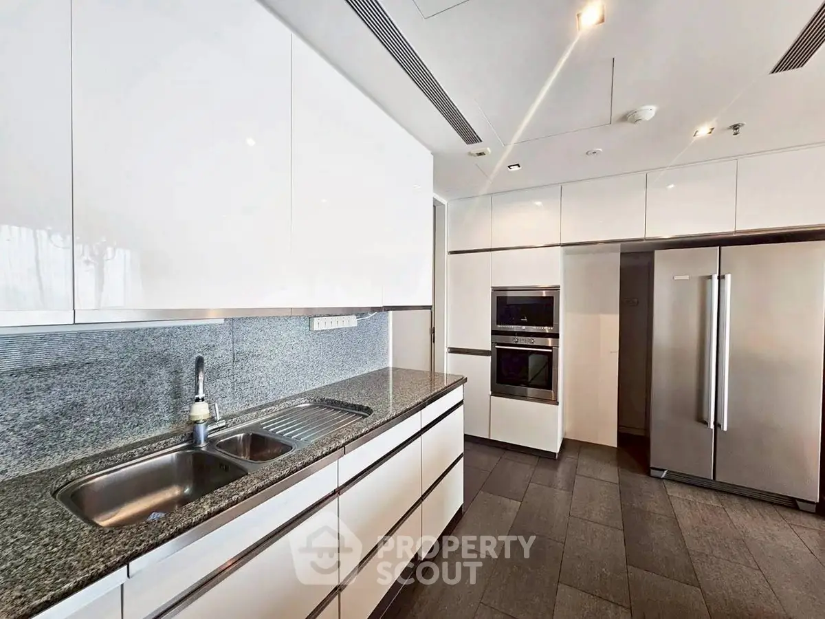Modern kitchen with sleek white cabinets and stainless steel appliances