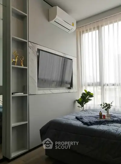 Modern bedroom with large window, built-in TV, and stylish decor
