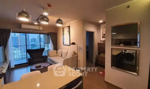 Modern living room with city view, stylish decor, and open layout in a high-rise apartment.