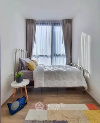 Cozy bedroom with modern decor and large window for natural light