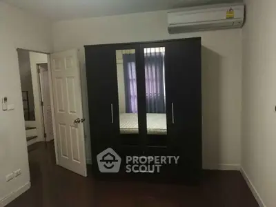 Spacious bedroom with modern wardrobe and air conditioning unit, perfect for comfortable living.