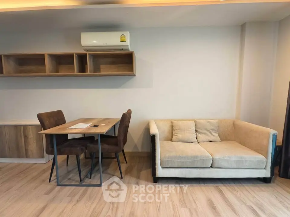 Modern living room with cozy sofa and stylish dining table in a well-lit apartment.