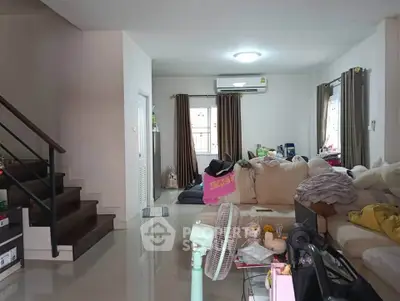 Spacious living room with modern staircase and cozy seating area, perfect for family gatherings.