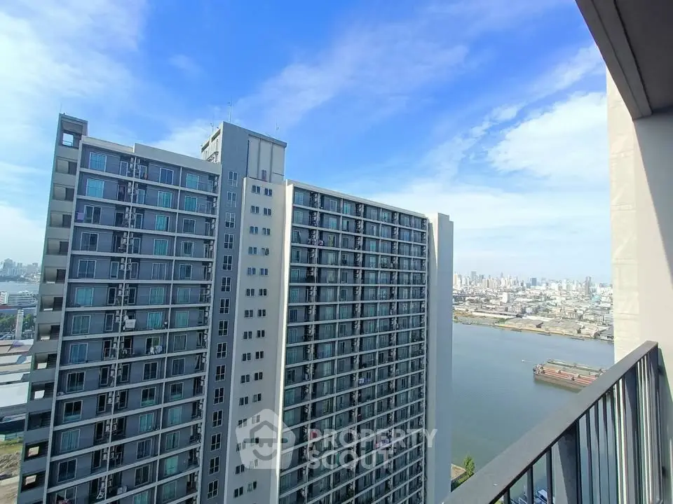 Stunning high-rise apartment view overlooking river and city skyline, perfect for urban living.