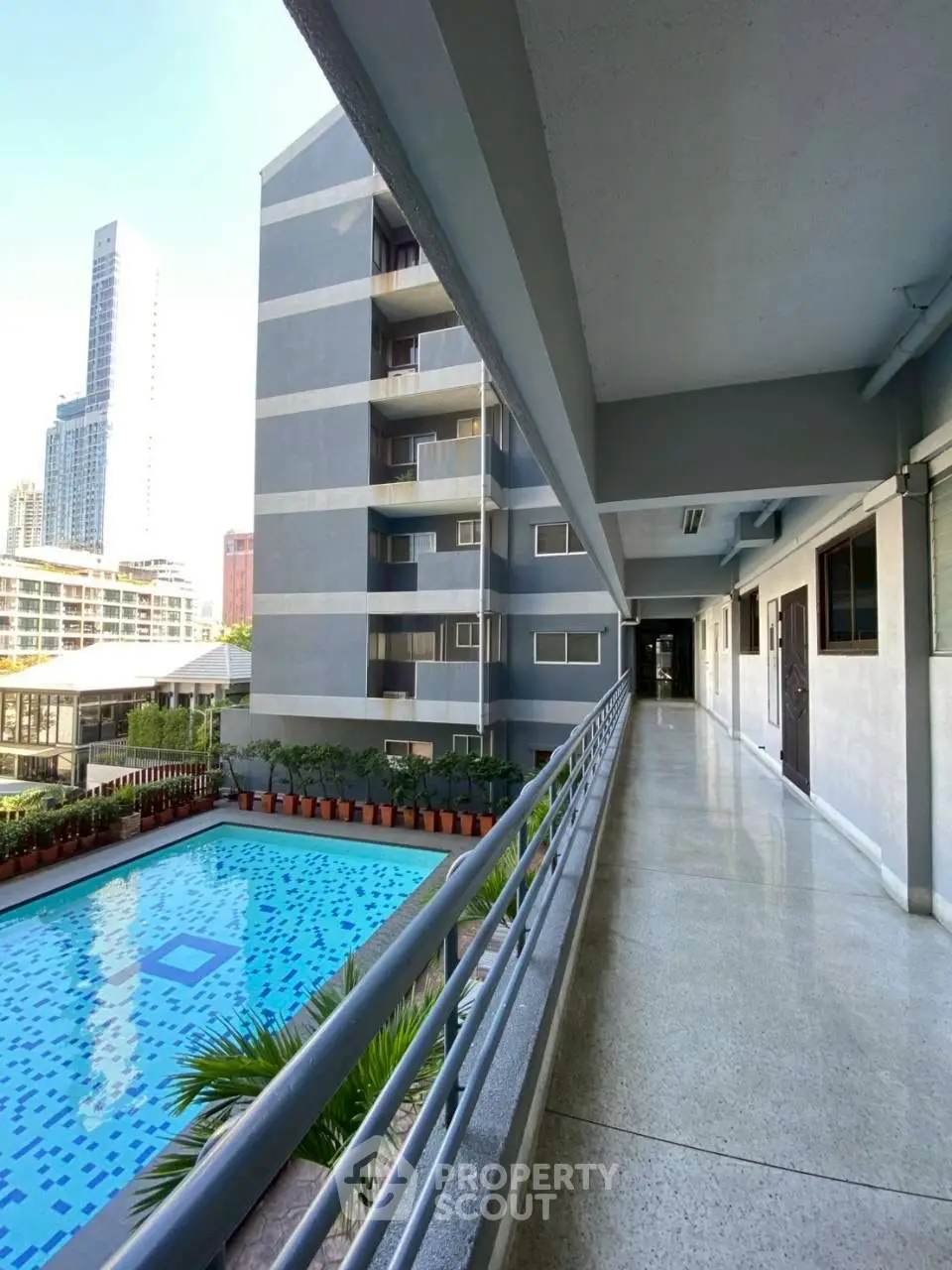 Modern apartment building with pool view and city skyline